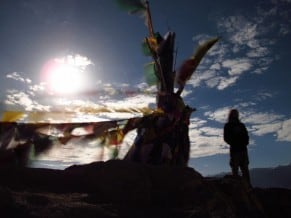 man contemplating under prayer flags