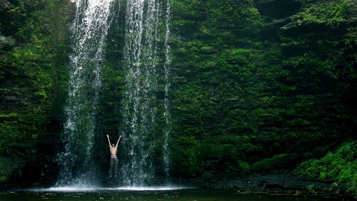 Standing under waterfall