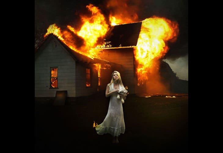 Woman in front of burning house - compassion