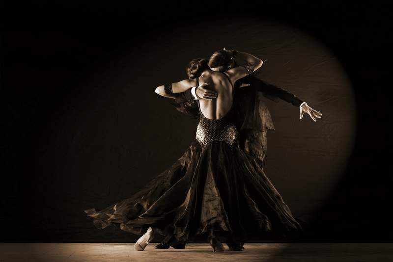 Man and woman ballroom dancers on black background