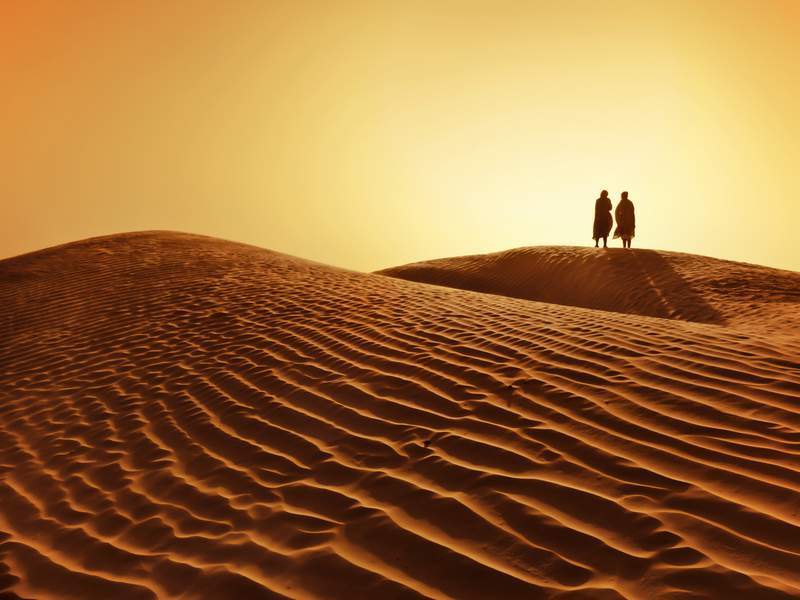 Couple walking in the Sahara Desert