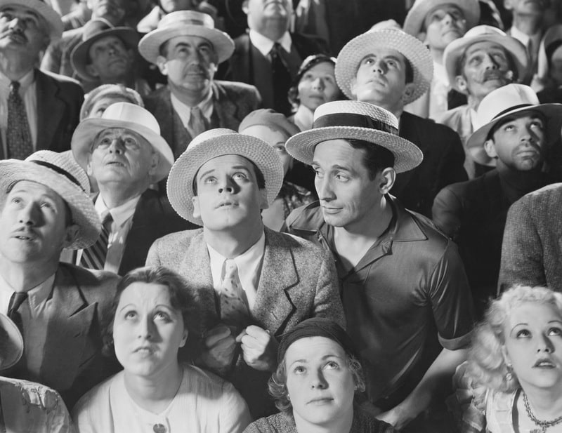 Crowd of people looking up at something