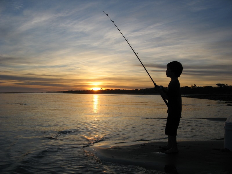 Boy fishing at sunset