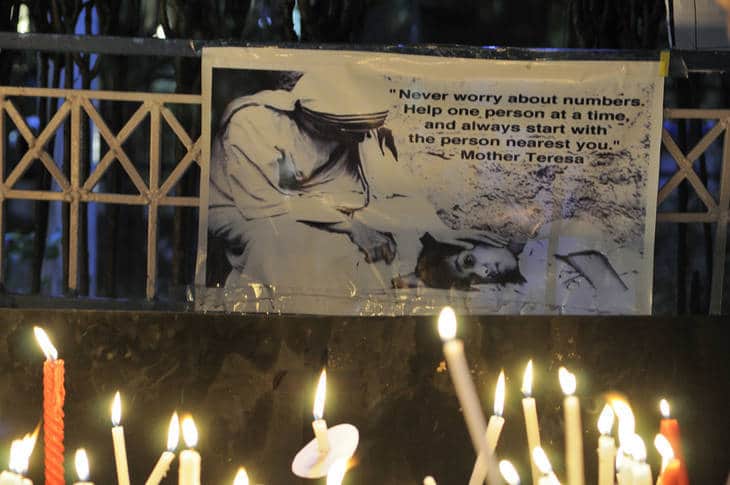 Candlelight vigil with Mother Teresa quote banner - Humour heals