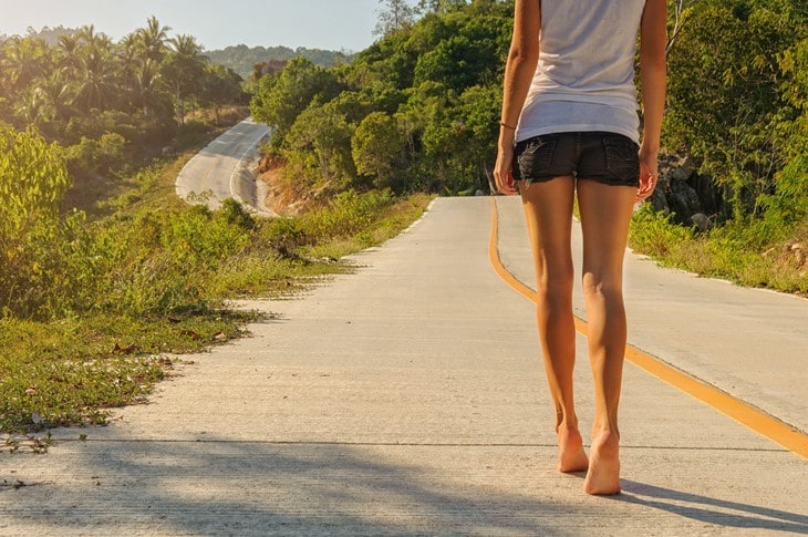 Woman walking on road barefoot