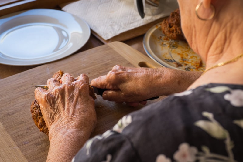 Grandmother's hands cutting meat