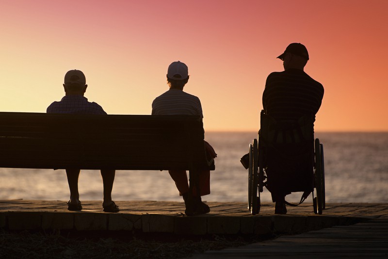 Slow living - Man in wheelchair watching the sunset