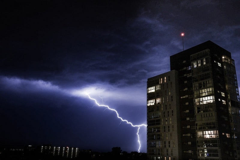 Lightning striking near tall building