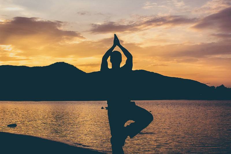 THE SCIENCE OF MIND-BODY: 3 therapies proven to improve your health 13 Man doing yoga on beach at sunset
