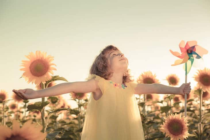 Blissful little girl with sunflowers - Teaching mindfulness to kids