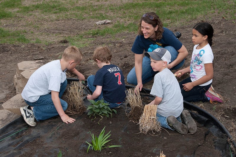 Four kids in park with caregiver - Kids, compassion and the environment