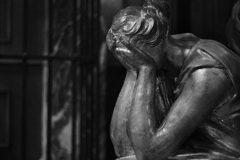 statue of woman with head in hands