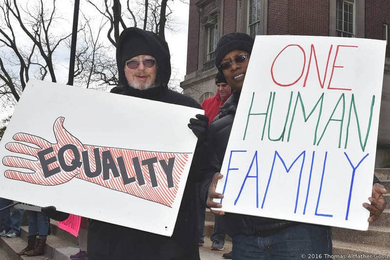 White man and black man with signs on U.S. Human Rights Day - Unexpected encounter