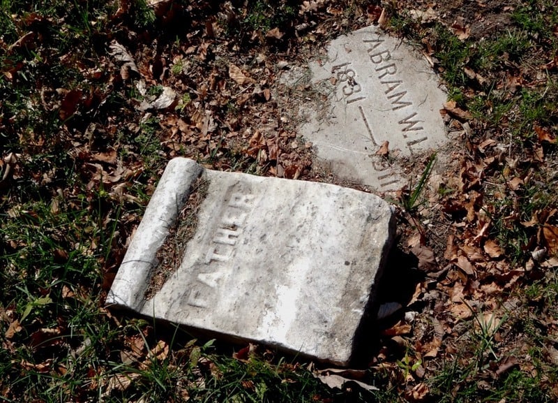 Tombstone lying in grass with word "Father"