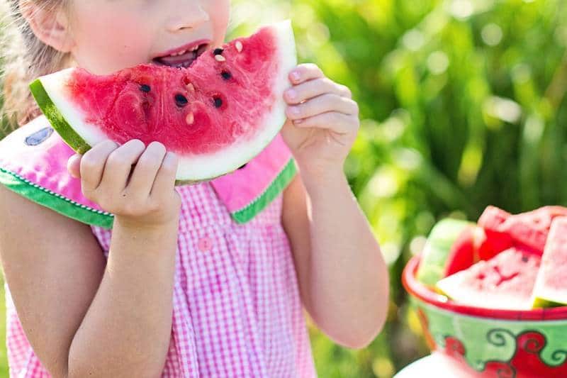 YOUNG "REDUCETARIANS": An introduction to meatless snacks and treats for kids 13 Little girl taking bite of watermelon - How to satisfy young fussy eaters