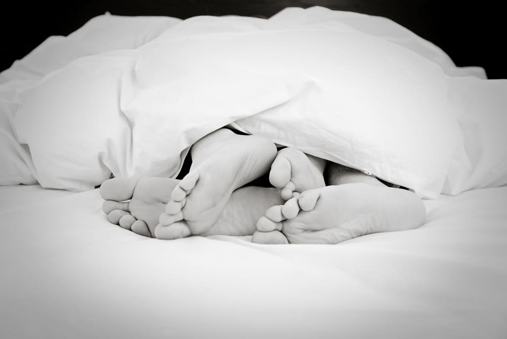 four feet sticking out from under the sheets