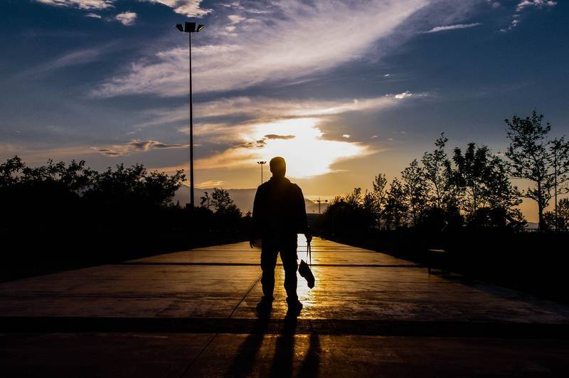 Man standing on boulevard at sunset - Poems by Mike Larcombe