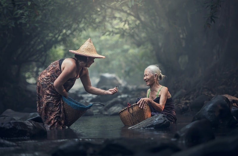 younger woman giving older woman food