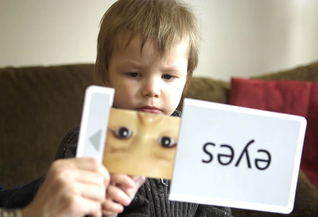 Young boy on autistic spectrum works with flash cards - A is for autism