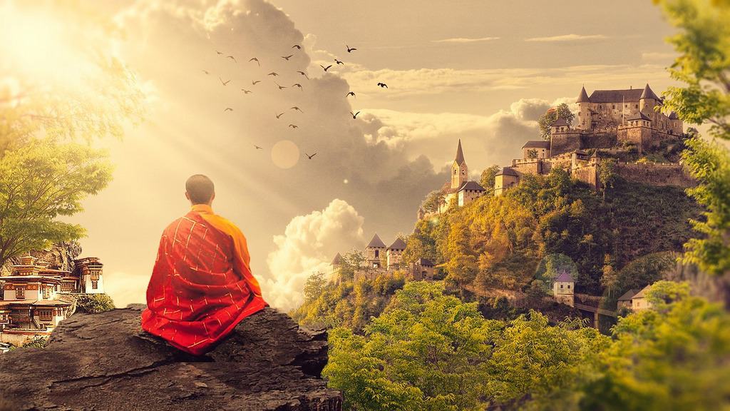 Buddhist monk meditating in mountains