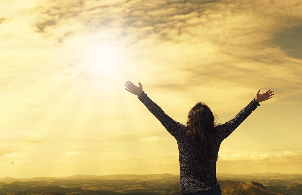Woman raising arms towards illuminated sky - Always new beginnings