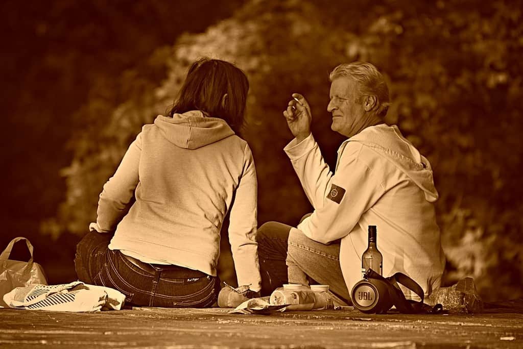 Man and woman in park with alcohol