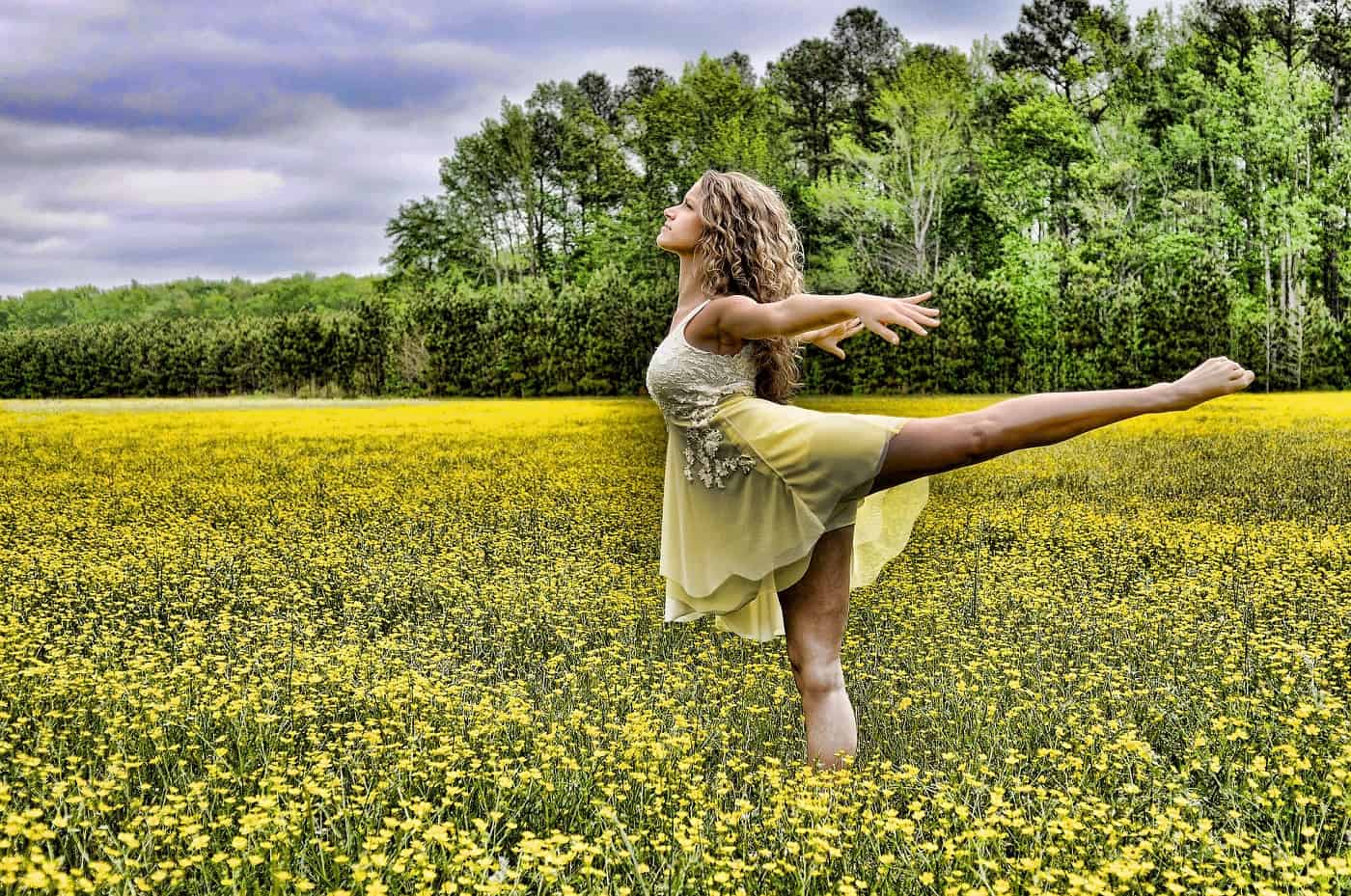 Woman balancing on one leg in field