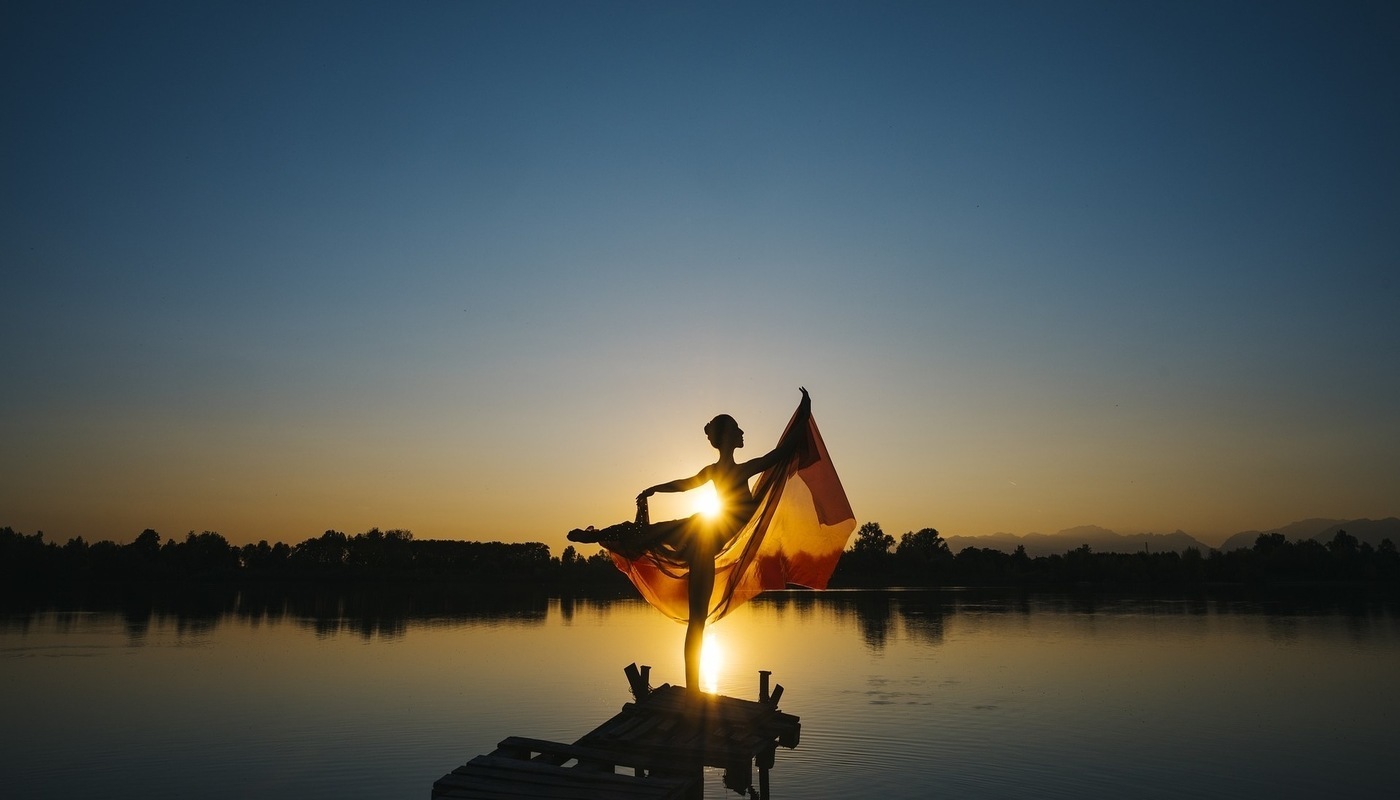 woman at sunset dancing in lake