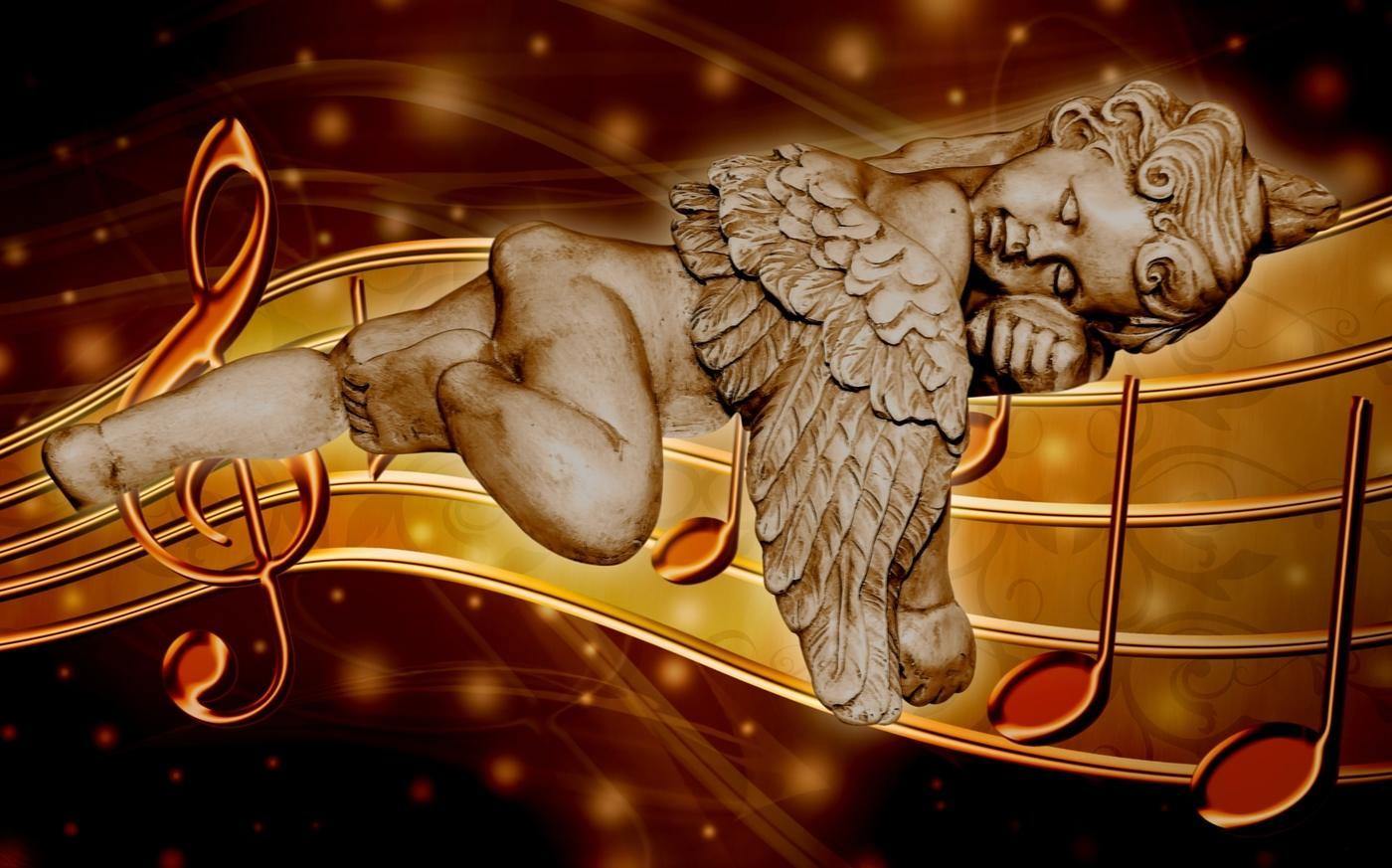 statue of a cupid sleeping on music score