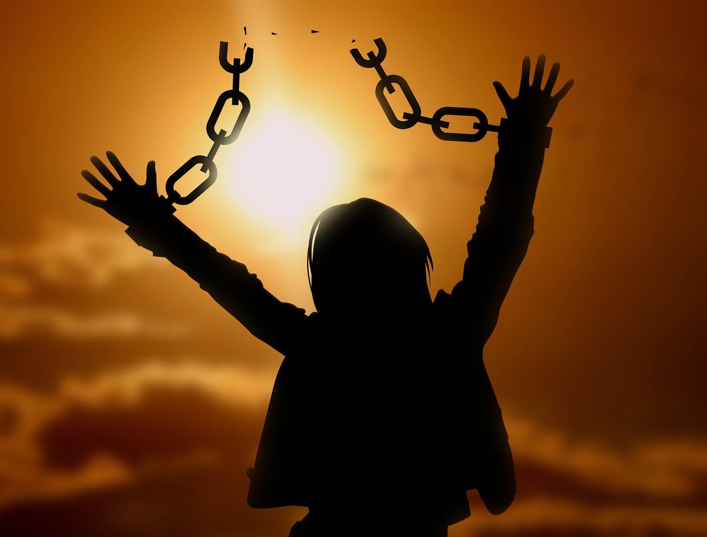 Silhouette of woman breaking free of chains