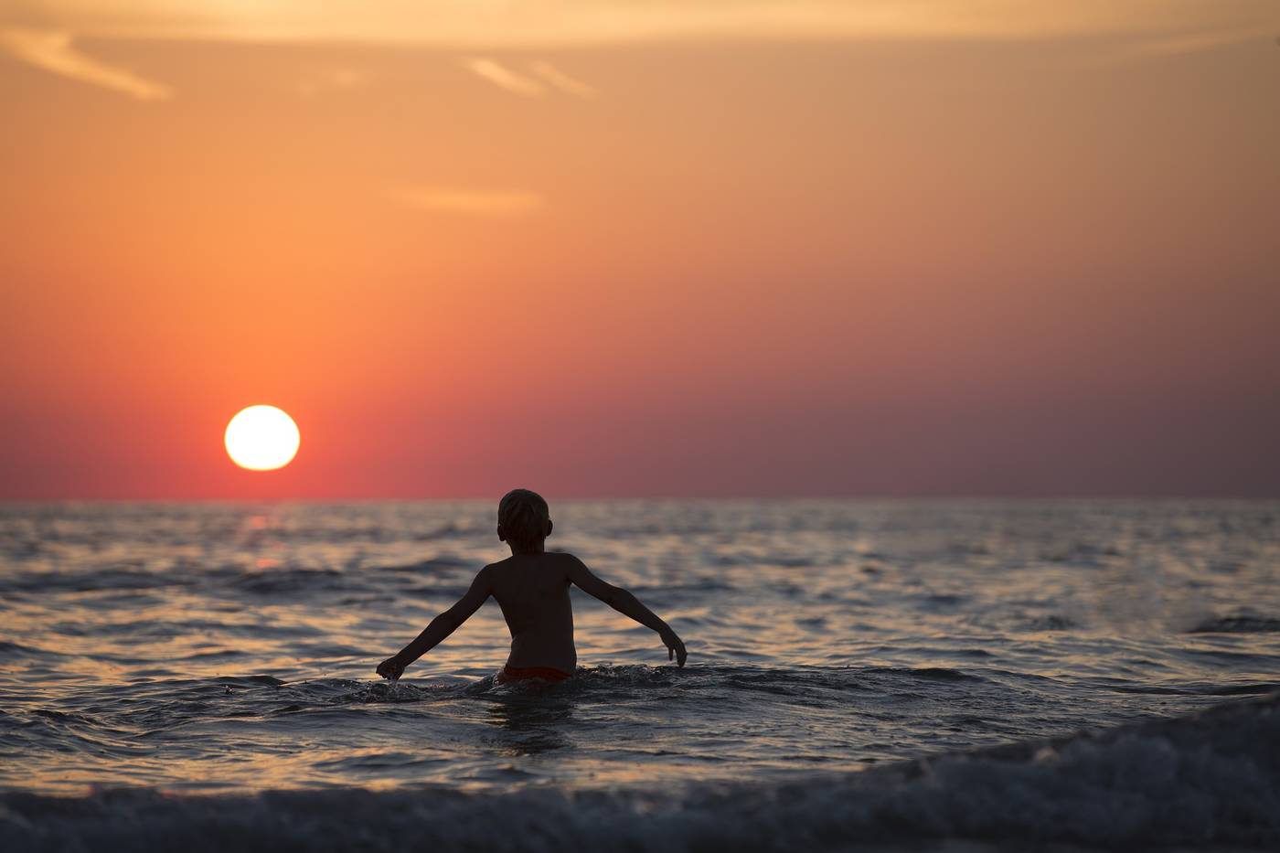Young boy swimming in lake