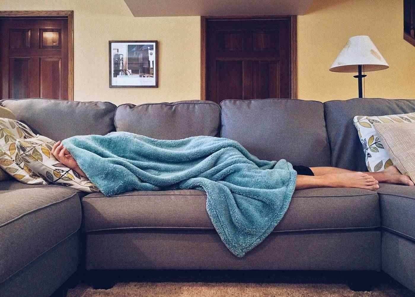 FORCED RELAXATION: Lessons learned while recovering from a concussion 13 Woman lying on couch, covered in blanket