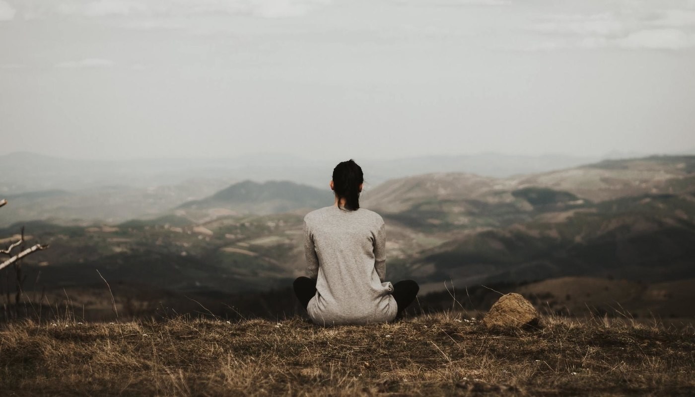woman sitting on mountain