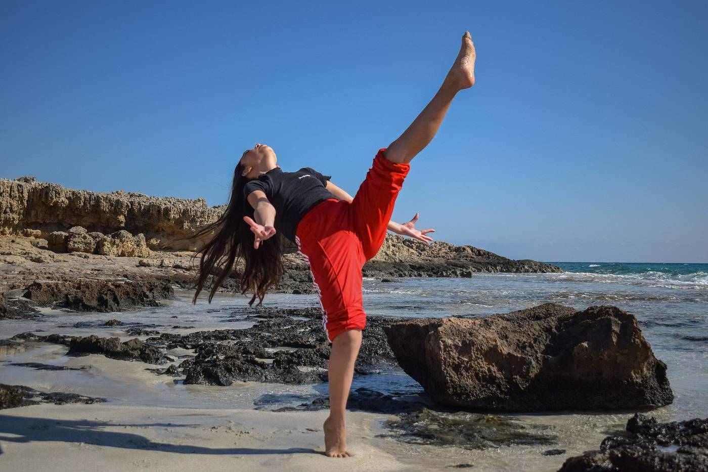 Girl dancing on rocky beach