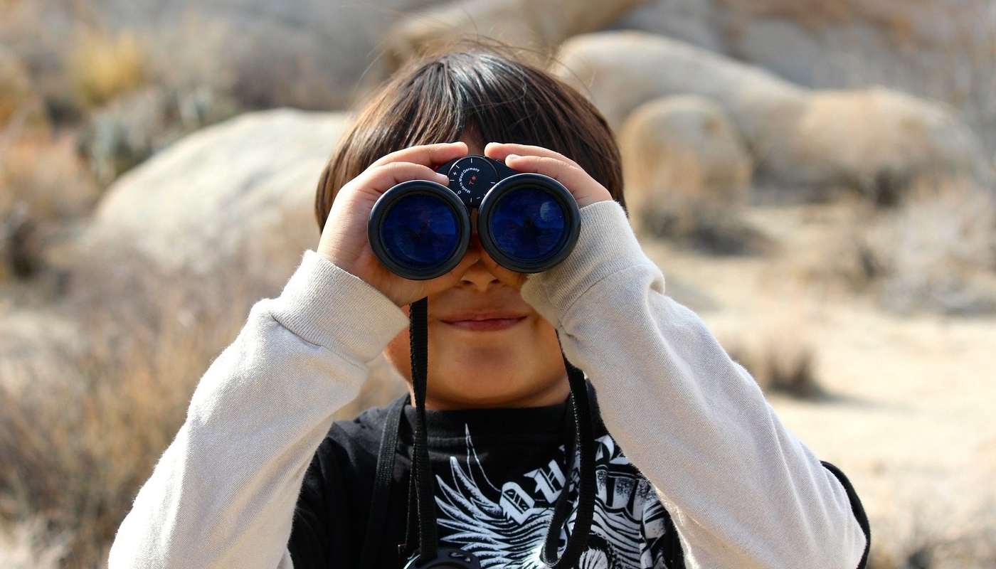 little boy looking through binoculars