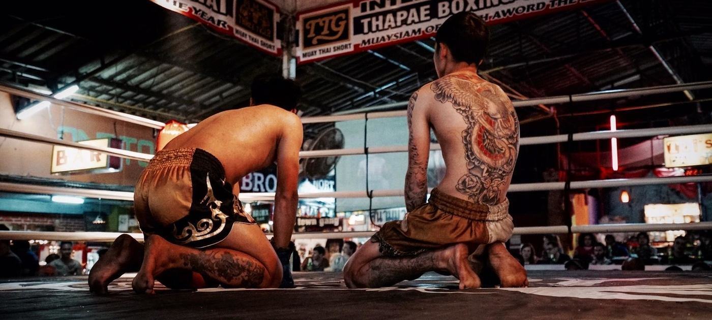 thai kick boxers kneeling in the middle of the ring