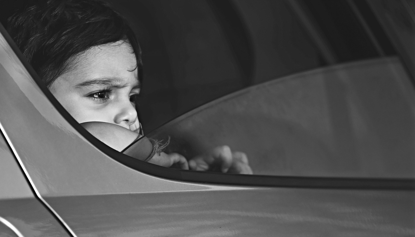 little boy looking out of a car window