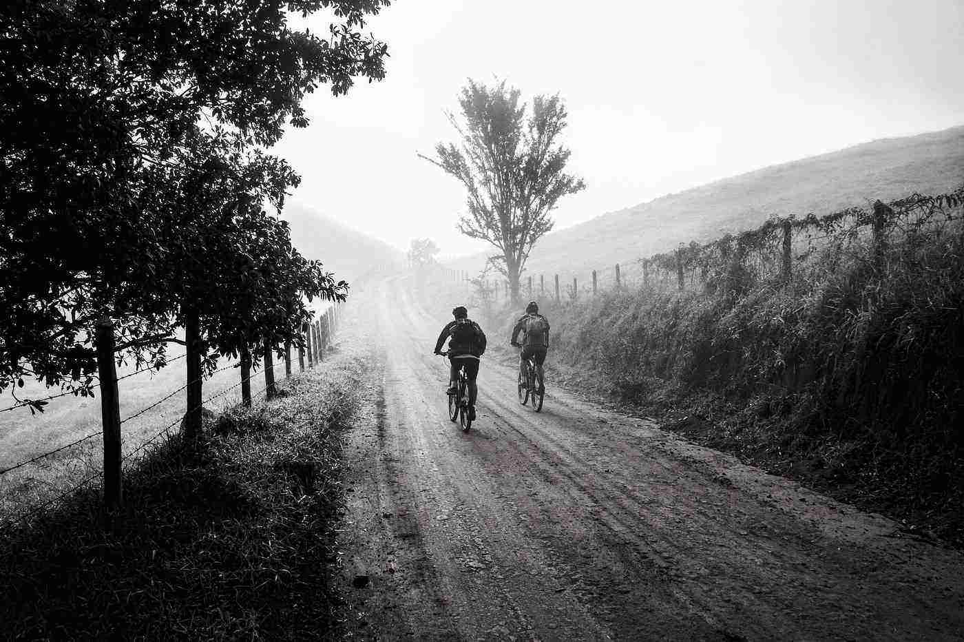 Two friends biking on trail