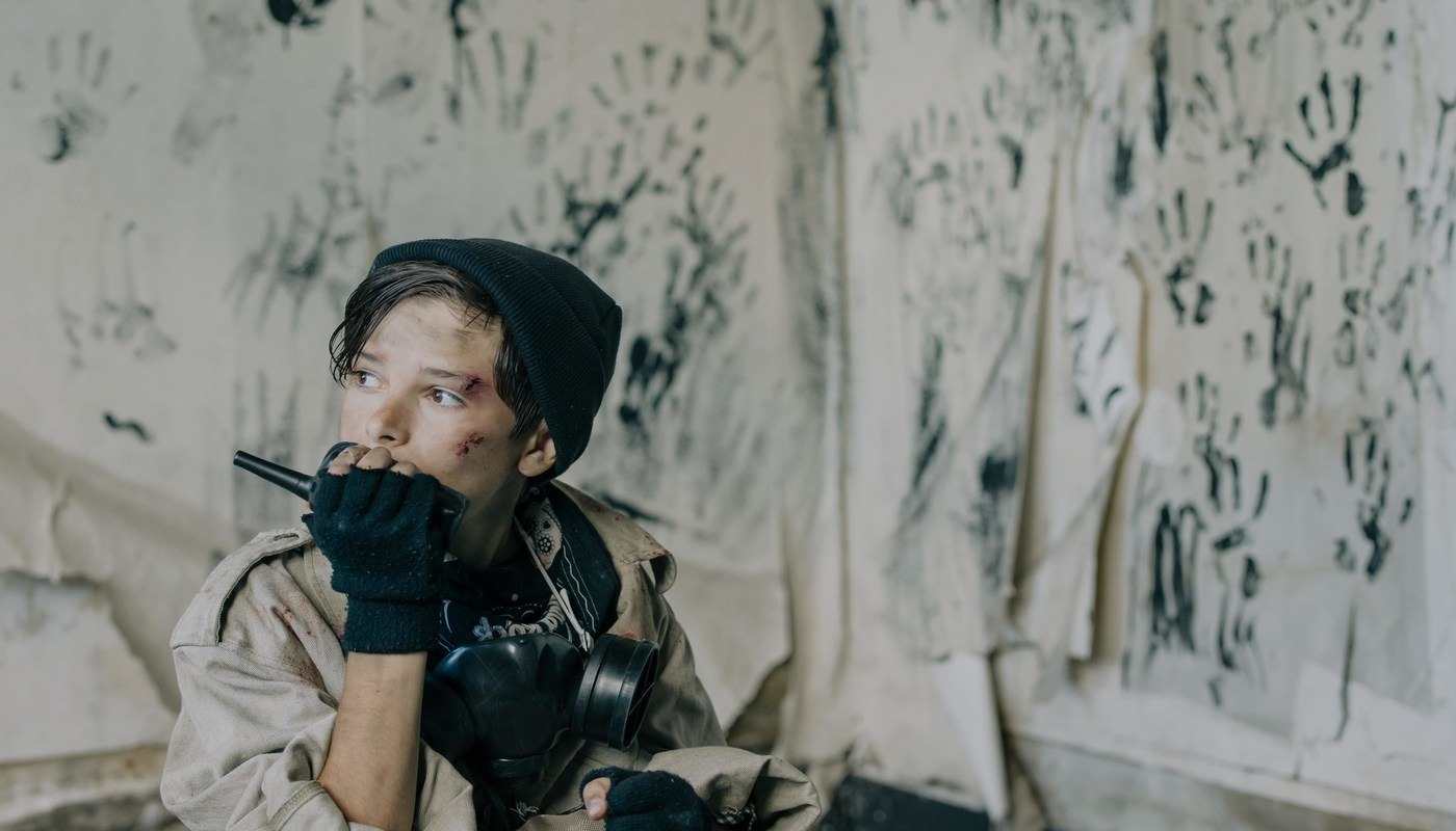 girl dressed strangely with handprints all over wall