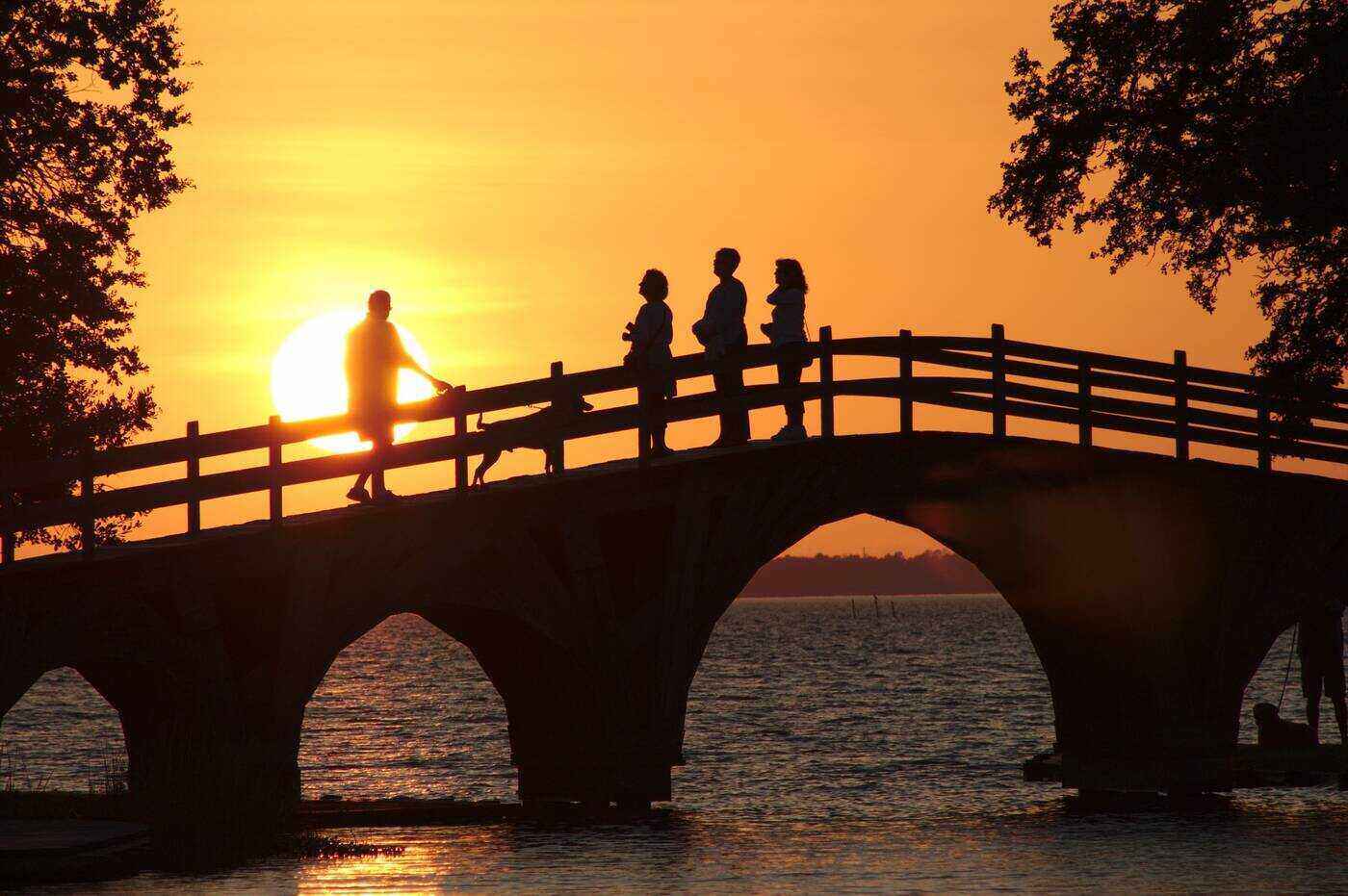 People on bridge at sunset
