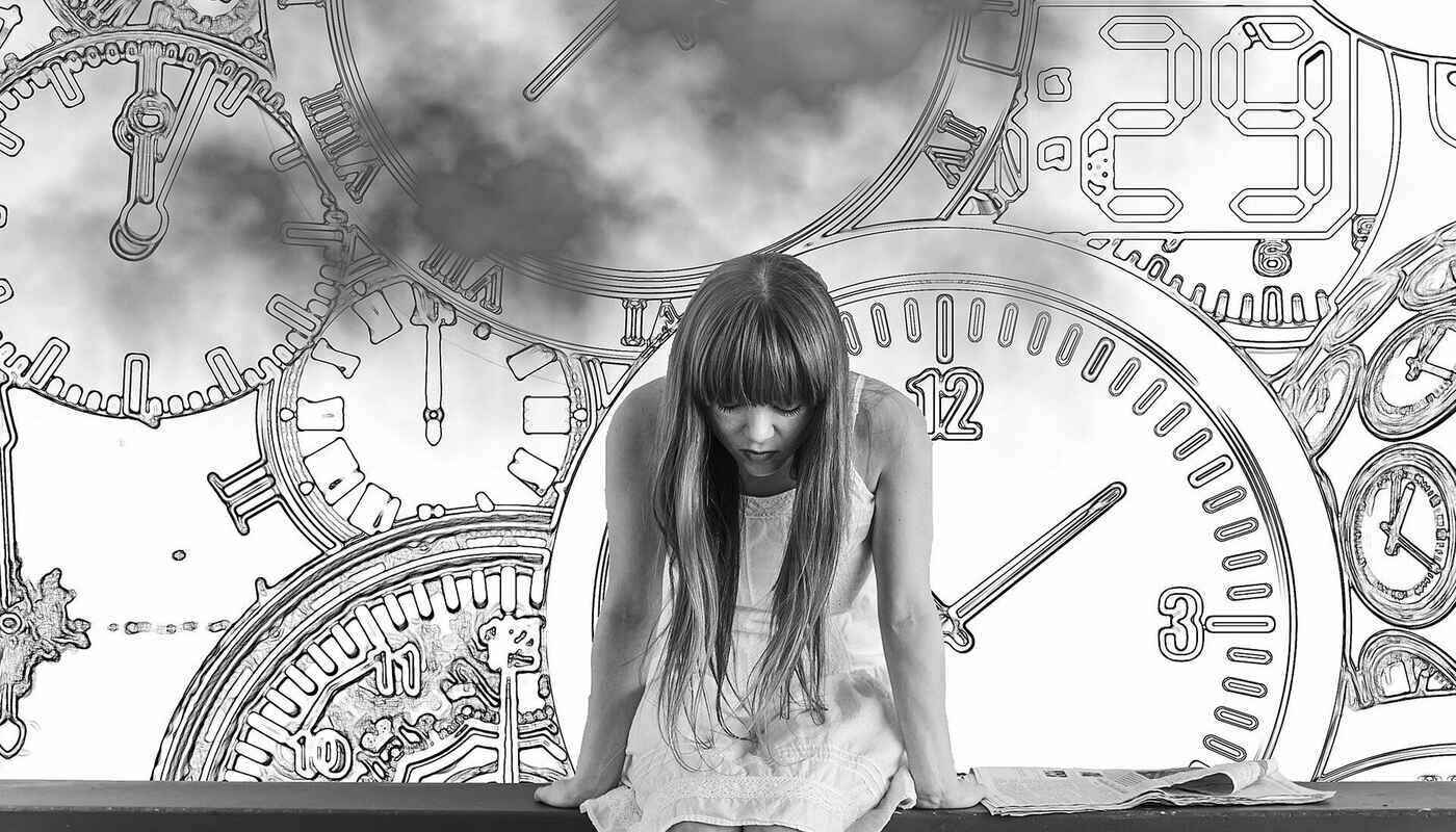 girl under pressure sitting in front of clock faces