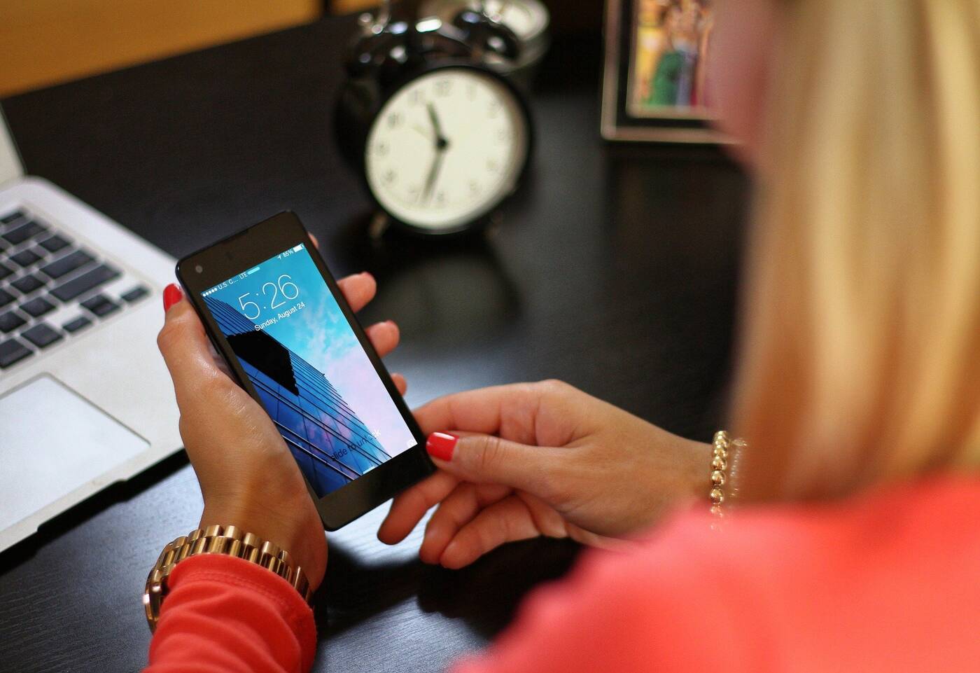 Woman looking at smartphone time at desk