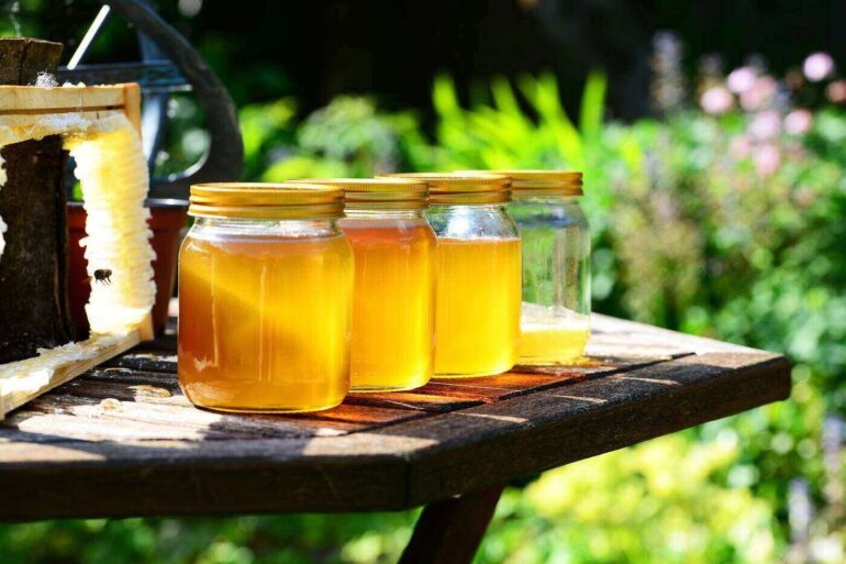 Jars of honey on outdoor table