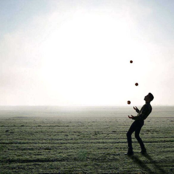 Juggler on beach beside white light