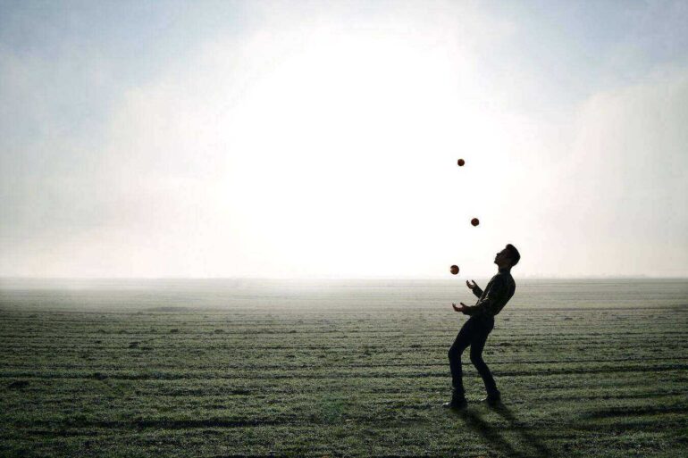 Juggler on beach beside white light