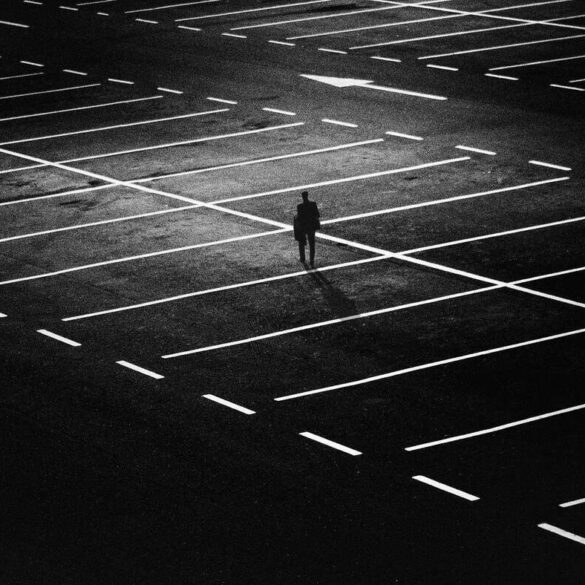 man alone at night in an empty parking lot