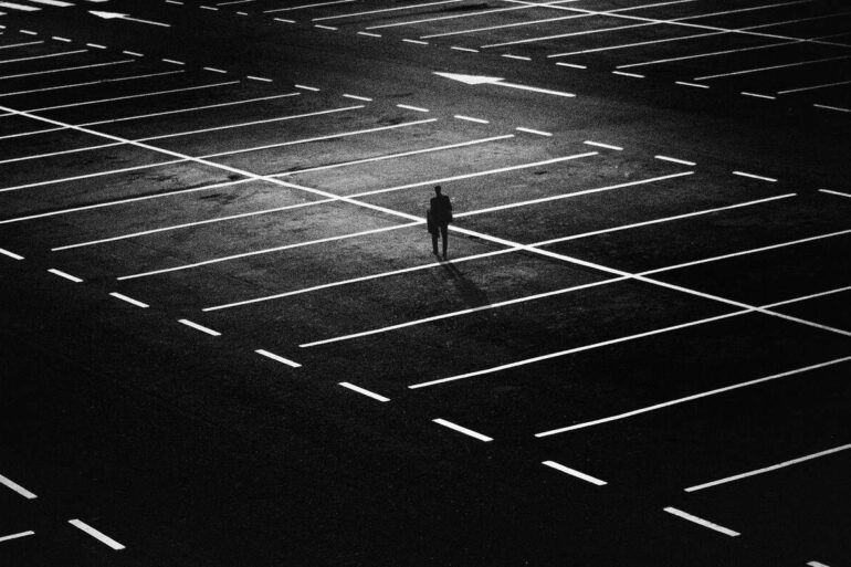 man alone at night in an empty parking lot