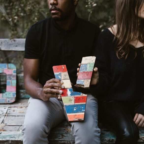 two people on a park bench breaking the word love