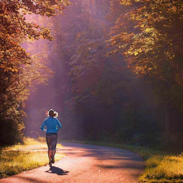 Woman running down country road in sun