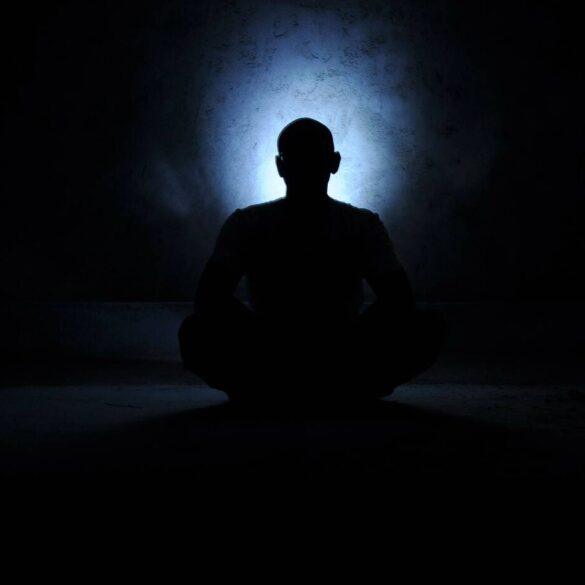Man meditating in dark, cavelike area